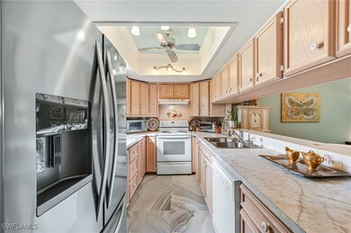 Kitchen featuring ceiling fan, sink, white applian
