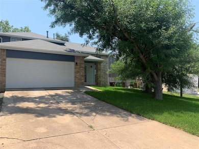 View of front of house featuring a front lawn, concrete driveway, a garage, and stone siding