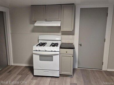 Kitchen with gas range gas stove, gray cabinetry, light wood finished floors, and under cabinet range hood