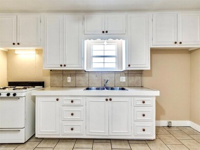 Kitchen featuring decorative backsplash, light cou