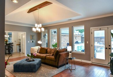 living room boasts a wet bar for entertaining, see through fire place and soaring windows to the backyard