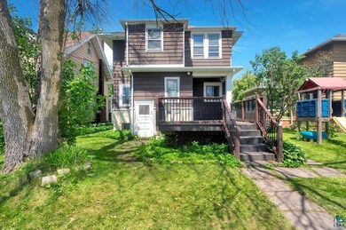 View of front facade with a deck and a front yard