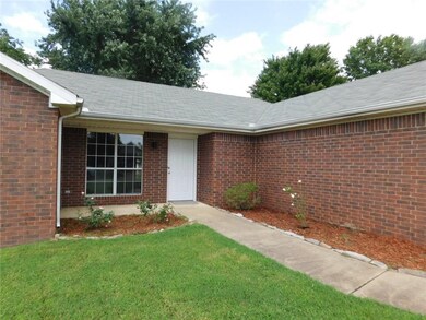 Very appealing front entryway with new mulch, plants. Home also has gutters and downspouts.