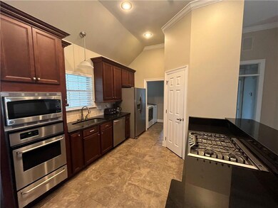 Another view showing the cooktop and island seating