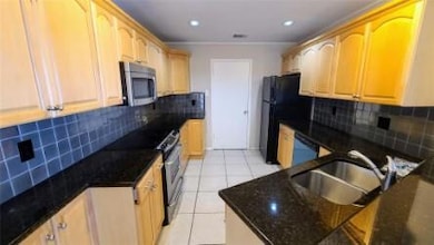 Kitchen featuring a sink, dark stone countertops,