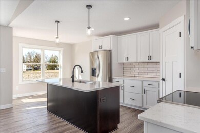 Spacious kitchen with Quartz countertops and tile backsplash.