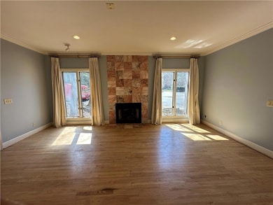 Unfurnished living room with crown molding, basebo