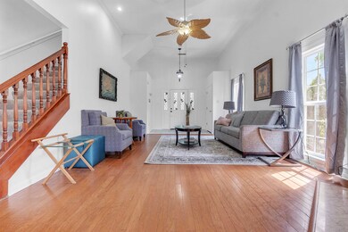 Living area with wood-type flooring, stairs, a cei
