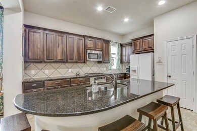 This kitchen is by far any chef’s dream! This spacious kitchen features high ceilings, dark stained cabinets, granite countertops, SS appliances, modern tile backsplash, recessed lighting and oversized kitchen island with a sink and space for a breakfast bar!