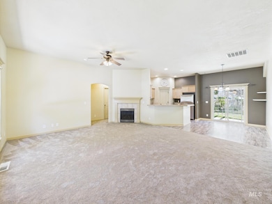 Unfurnished living room with a ceiling fan, a tiled fireplace, light carpet, and recessed lighting