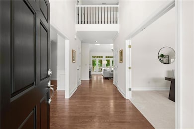 Welcoming two-story foyer with hardwood floors and open views into the main living space.