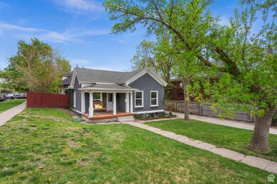 Bungalow-style house featuring a shingled roof, stucco siding, and a porch