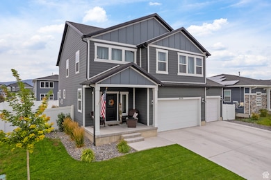 Craftsman-style home featuring board and batten siding, a porch, a garage, and concrete driveway