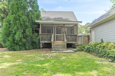 Back of house featuring a sunroom and a shingled roof