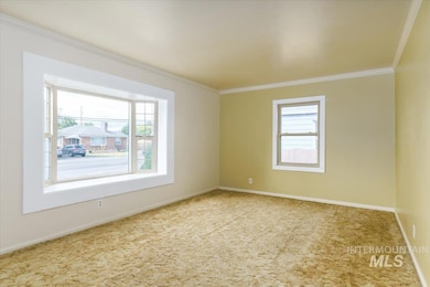 Unfurnished room featuring carpet and crown molding