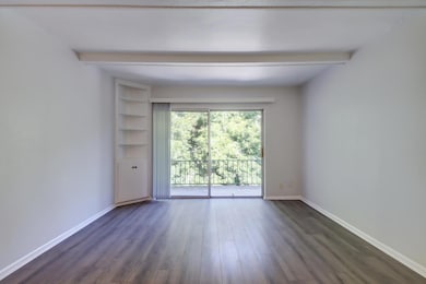 Unfurnished room featuring beam ceiling and dark 