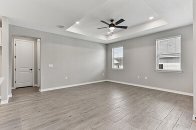 Unfurnished room with light wood-type flooring, a tray ceiling, a ceiling fan, and recessed lighting