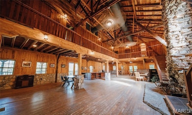 Misc room with hardwood / wood-style flooring, high vaulted ceiling, wooden walls, and beamed ceiling