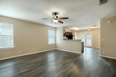 Unfurnished living room with ceiling fan, dark wo