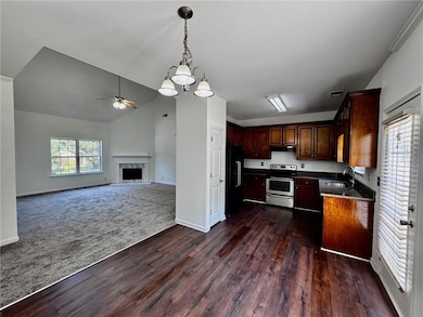 Kitchen with a sink, electric range, dark wood fin
