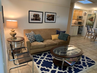 Living room with a skylight and light tile patter