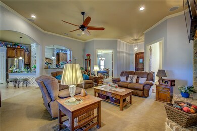 Living room featuring crown molding, ceiling fan, light carpet and recessed lighting.
