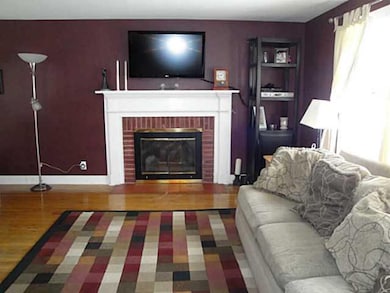Living Room. Woodburning fireplace and hardwood fl