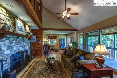 Great room with beautiful stone fireplace is open to another sitting area, and covered back porch.
