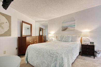 Bedroom with a textured ceiling and light colored 