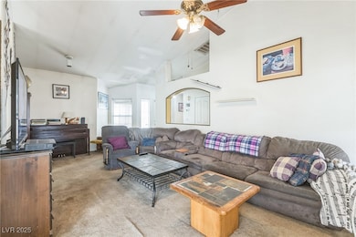 Carpeted living room with vaulted ceiling, visible