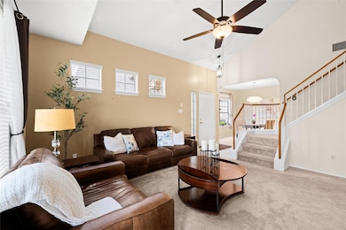 Living area with visible vents, a ceiling fan, st