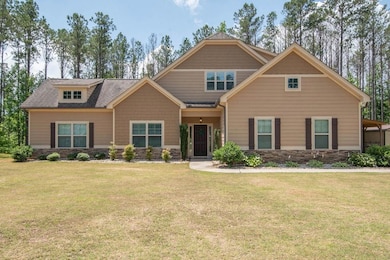 Craftsman-style home with stone siding and a front lawn