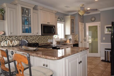 Kitchen featuring a kitchen bar, sink, decorative backsplash, and kitchen peninsula