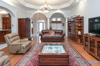 Beautiful room with Trey Ceiling, large light fixtures, recessed lighting, gas log fireplace and decorative mantle, nice hardwoods! The archways and columns makes this an elegant room.