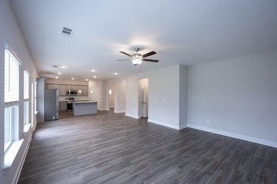 Unfurnished living room with baseboards, visible vents, ceiling fan, dark wood-style flooring, and recessed lighting
