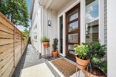 Bright entryway with hardwood floors, a modern gla