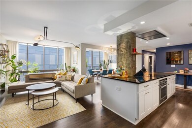 Kitchen with stainless steel oven, dark countertops, white cabinets, dark wood finished floors, and plenty of natural light