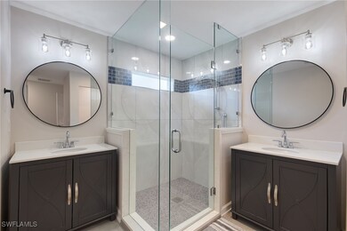 Bathroom featuring double sink vanity and an enclo