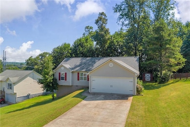 View of front of home featuring driveway, an attached garage, and a storage shed