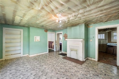 Unfurnished living room with a fireplace, tile patterned floors, baseboards, and a ceiling fan