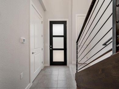 Entryway featuring light tile patterned floors, b