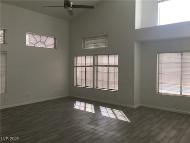 Spare room with high vaulted ceiling, ceiling fan, and dark wood finished floors