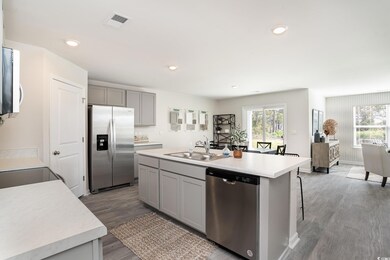 Kitchen with stainless steel appliances, gray cabinetry, light countertops, wood finished floors, and recessed lighting