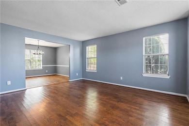 Empty room featuring visible vents, an inviting ch