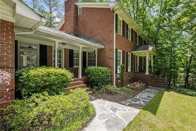 Property entrance featuring brick siding, a porch, a yard, and a chimney