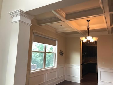 Unfurnished dining area with coffered ceiling, wai