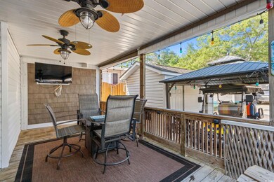 Deck with a gazebo, outdoor dining area, and ceiling fan
