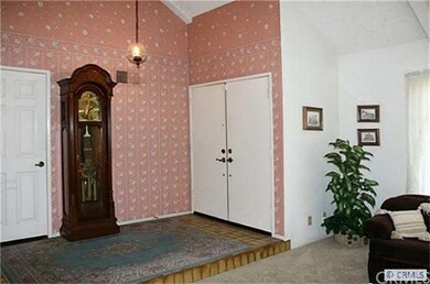 Double Entry Doors Open to Tiled Foyer and Soaring