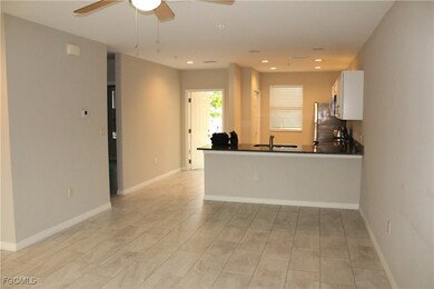 Kitchen featuring white cabinets, dark countertops, a peninsula, ceiling fan, and recessed lighting