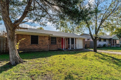 Ranch-style house featuring a front yard and a gar